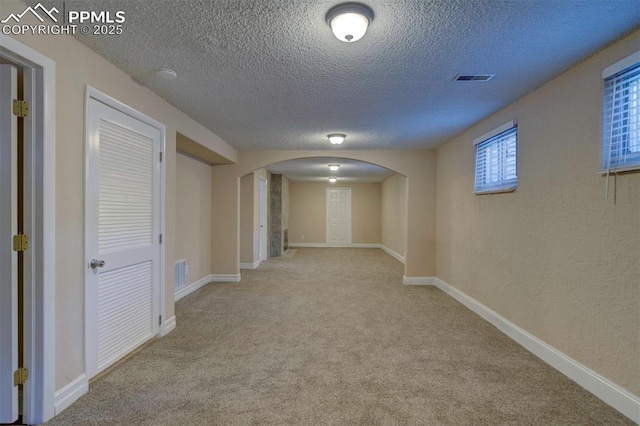 2928 Nevermind Ln, Colorado Springs, CO 80917 - hall featuring arched walkways, a textured ceiling, and carpet flooring