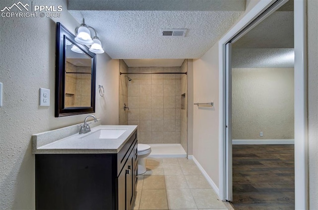 2928 Nevermind Ln, Colorado Springs, CO 80917 - full bath with vanity, a textured ceiling, a tile shower, a textured wall, and tile patterned flooring