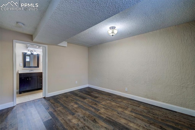 2928 Nevermind Ln, Colorado Springs, CO 80917 - unfurnished bedroom with wood finished floors, a textured ceiling, a textured wall, and connected bathroom