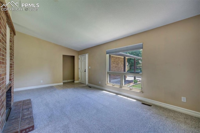 2928 Nevermind Ln, Colorado Springs, CO 80917 - unfurnished living room with carpet floors, lofted ceiling, and a fireplace