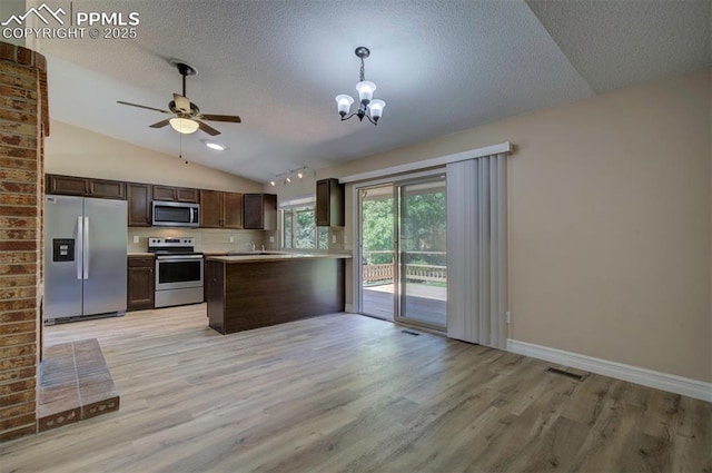 2928 Nevermind Ln, Colorado Springs, CO 80917 - kitchen with stainless steel appliances, dark brown cabinetry, light wood-type flooring, lofted ceiling, and a textured ceiling