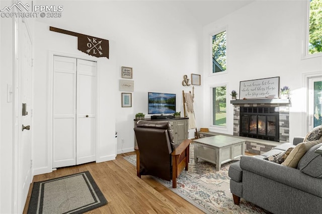55 Woodbridge Dr, Colorado Springs, CO 80906 - living room with high vaulted ceiling, wood finished floors, and a tiled fireplace