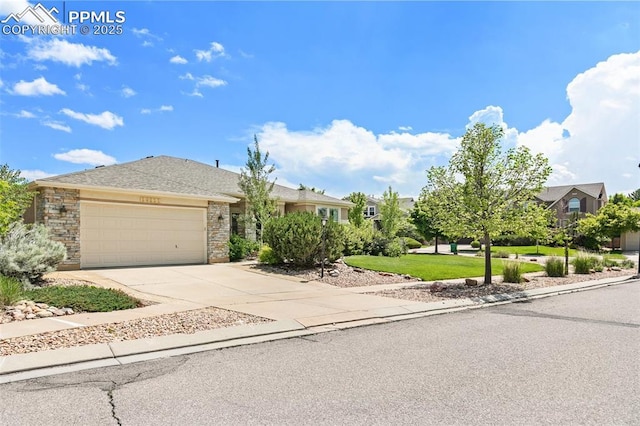 10211 Murmuring Pine Ct, Colorado Springs, CO 80920 - view of front of home with a garage, concrete driveway, stone siding, and a front yard