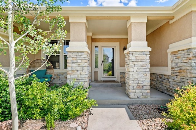 10211 Murmuring Pine Ct, Colorado Springs, CO 80920 - doorway to property featuring stone siding, stucco siding, and covered porch