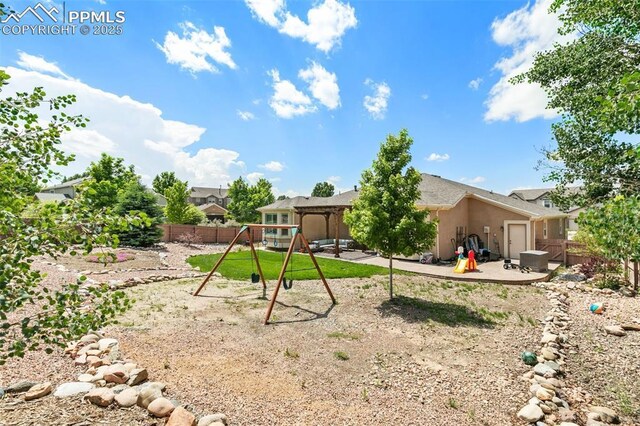 10211 Murmuring Pine Ct, Colorado Springs, CO 80920 - rear view of house featuring a playground, a patio area, a fenced backyard, and stucco siding