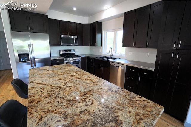 1407 Manitou Blvd, Colorado Springs, CO 80904 - kitchen with stainless steel appliances, light wood-type flooring, dark cabinetry, light stone countertops, and recessed lighting