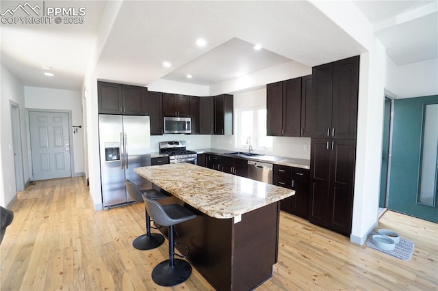 1407 Manitou Blvd, Colorado Springs, CO 80904 - kitchen featuring stainless steel appliances, light wood-style flooring, a kitchen island, a breakfast bar area, and light stone countertops