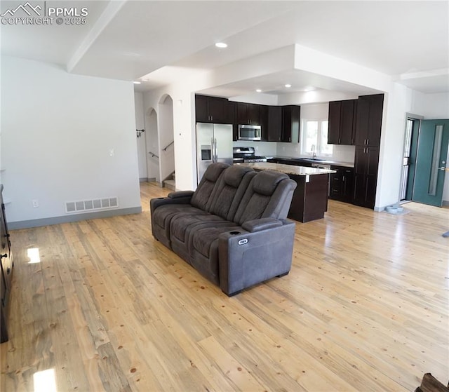 1407 Manitou Blvd, Colorado Springs, CO 80904 - living room with arched walkways, light wood finished floors, recessed lighting, and stairway