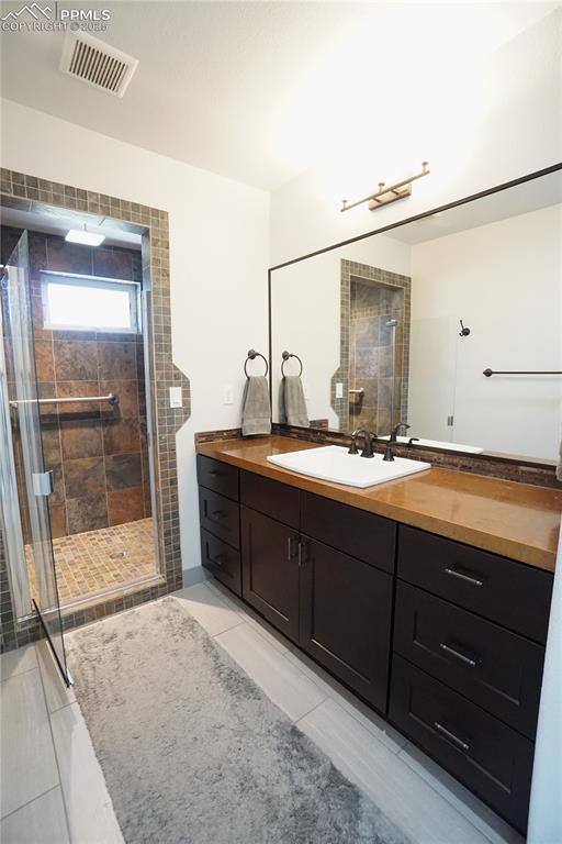 1407 Manitou Blvd, Colorado Springs, CO 80904 - bathroom featuring tile patterned flooring, a shower stall, and vanity