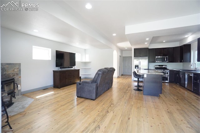 1407 Manitou Blvd, Colorado Springs, CO 80904 - living room with arched walkways, light wood-style floors, recessed lighting, and a wood stove