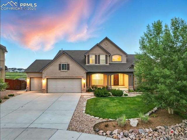 13080 Mt Harvard Dr, Peyton, CO 80831 - traditional home featuring concrete driveway, stucco siding, an attached garage, a porch, and a shingled roof