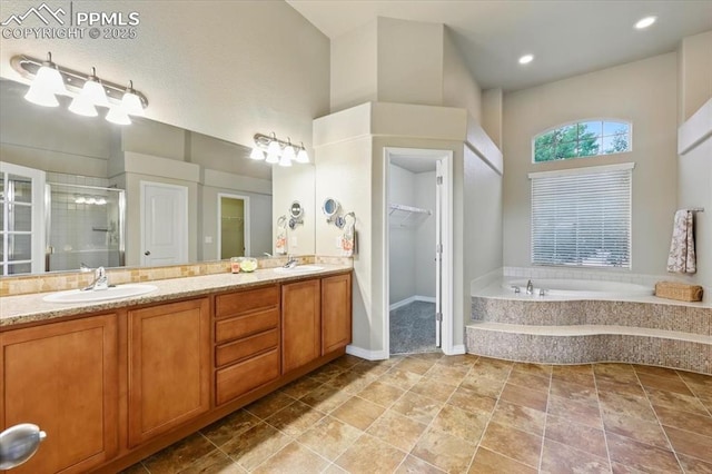 13080 Mt Harvard Dr, Peyton, CO 80831 - bathroom with double vanity, a shower stall, a bath, a towering ceiling, and a walk in closet