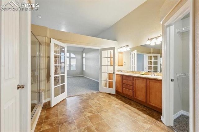 13080 Mt Harvard Dr, Peyton, CO 80831 - full bath with french doors, double vanity, a stall shower, and vaulted ceiling