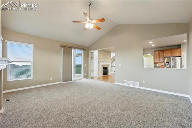 13080 Mt Harvard Dr, Peyton, CO 80831 - unfurnished living room with ceiling fan, healthy amount of natural light, a fireplace, carpet flooring, and high vaulted ceiling