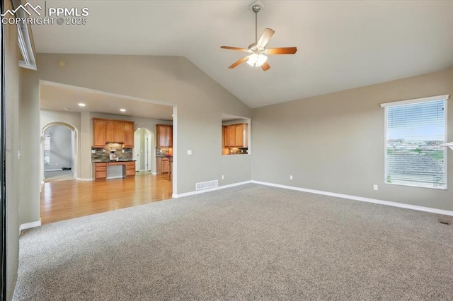 13080 Mt Harvard Dr, Peyton, CO 80831 - unfurnished living room featuring light carpet, arched walkways, a ceiling fan, lofted ceiling, and recessed lighting