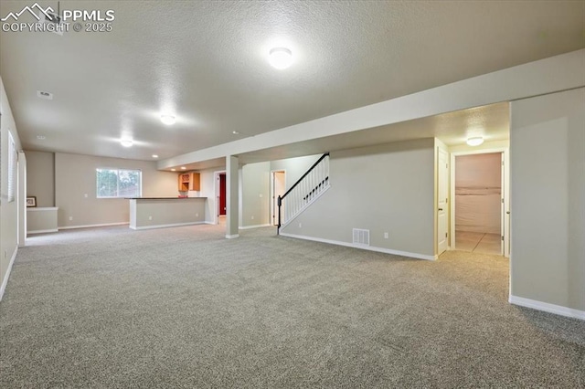 13080 Mt Harvard Dr, Peyton, CO 80831 - below grade area featuring light colored carpet, stairs, and a textured ceiling