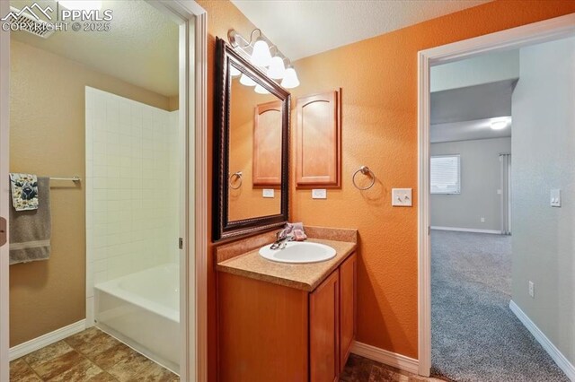 13080 Mt Harvard Dr, Peyton, CO 80831 - bathroom with vanity, a textured wall, and shower / tub combination