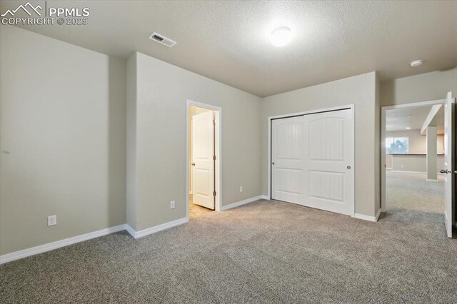 13080 Mt Harvard Dr, Peyton, CO 80831 - unfurnished bedroom with carpet flooring, a textured ceiling, a closet, and ensuite bath