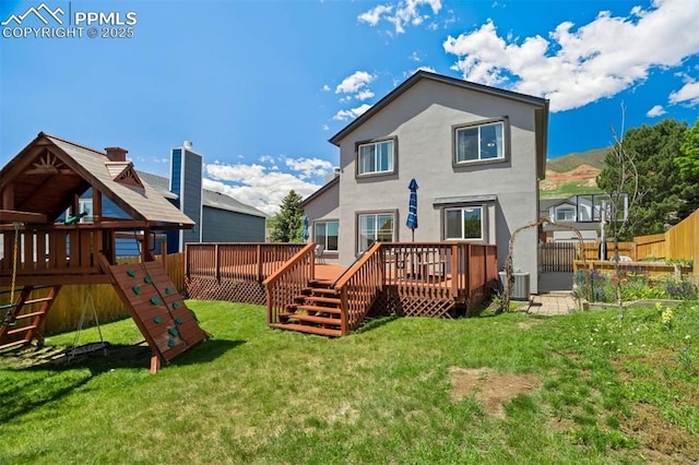 2852 Front Royal Dr, Colorado Springs, CO 80919 - rear view of house with a deck, a playground, and stucco siding