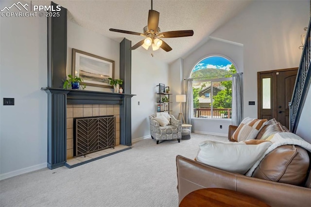 2852 Front Royal Dr, Colorado Springs, CO 80919 - carpeted living room featuring a tiled fireplace, ceiling fan, a textured ceiling, and vaulted ceiling