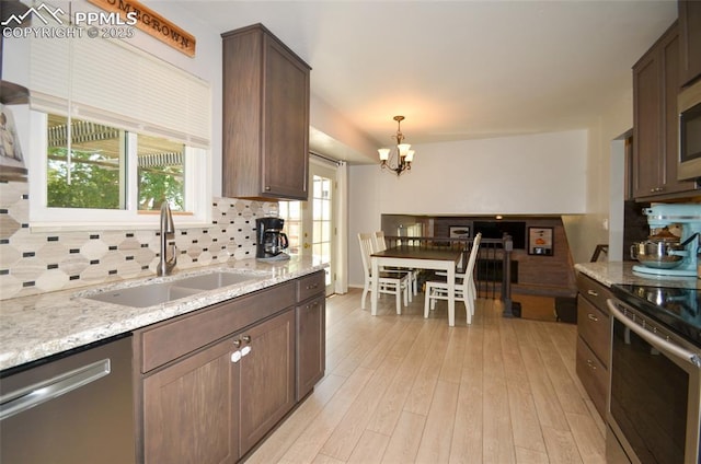 4075 Undimmed Cir, Colorado Springs, CO 80917 - kitchen featuring stainless steel appliances, a chandelier, backsplash, and light stone counters