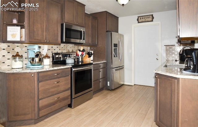 4075 Undimmed Cir, Colorado Springs, CO 80917 - kitchen featuring stainless steel appliances, decorative backsplash, and light wood-type flooring