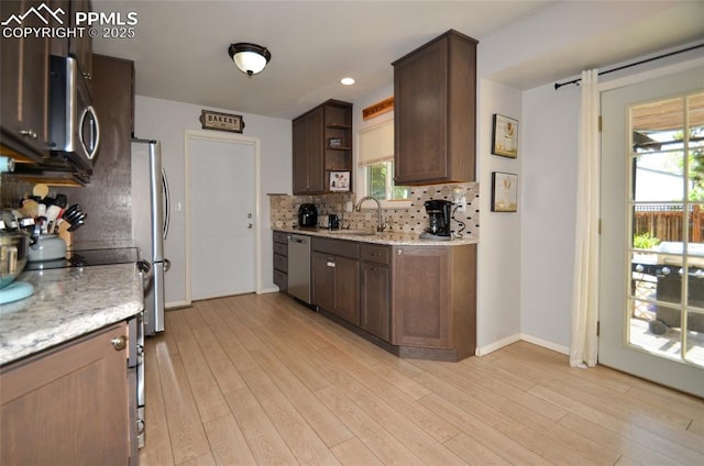 4075 Undimmed Cir, Colorado Springs, CO 80917 - kitchen featuring appliances with stainless steel finishes, open shelves, decorative backsplash, light wood-type flooring, and recessed lighting