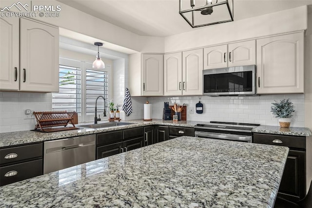 2570 Wimbleton Ct, Colorado Springs, CO 80920 - kitchen featuring appliances with stainless steel finishes, white cabinets, light stone countertops, and backsplash