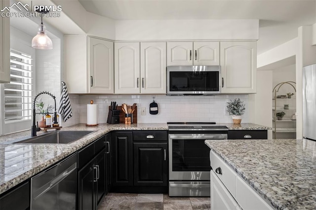 2570 Wimbleton Ct, Colorado Springs, CO 80920 - kitchen with stainless steel appliances, dark cabinetry, white cabinets, and light stone counters