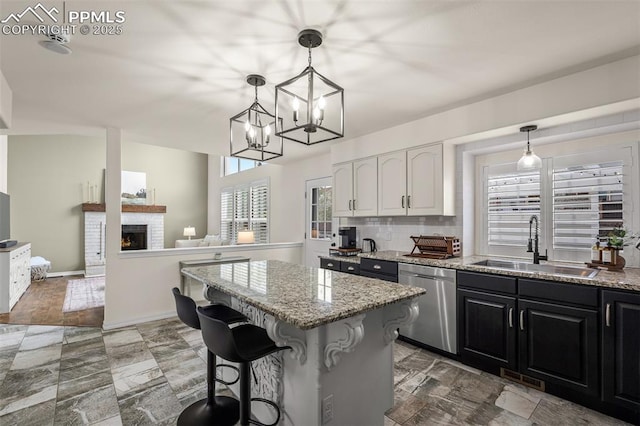 2570 Wimbleton Ct, Colorado Springs, CO 80920 - kitchen featuring dishwasher, plenty of natural light, light stone counters, and a kitchen island