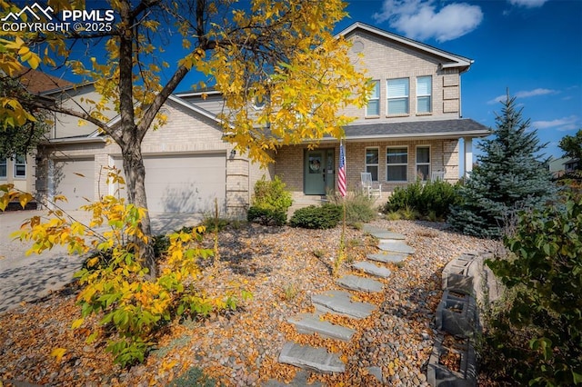 2570 Wimbleton Ct, Colorado Springs, CO 80920 - view of front of property with brick siding, covered porch, an attached garage, and driveway