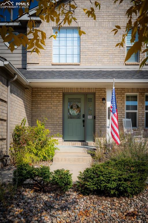 2570 Wimbleton Ct, Colorado Springs, CO 80920 - property entrance with brick siding and a shingled roof