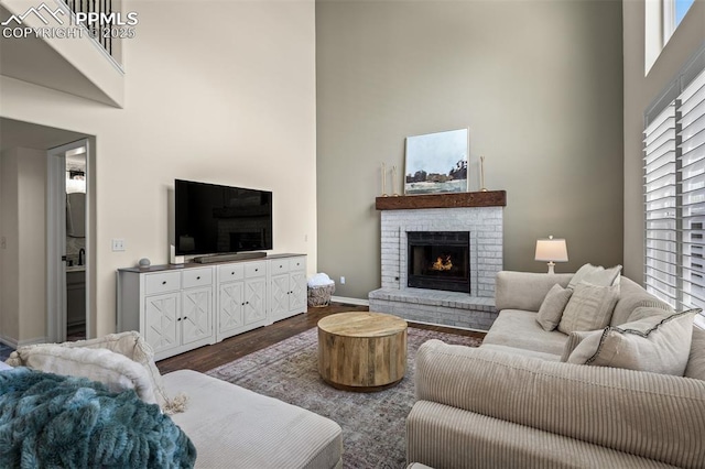 2570 Wimbleton Ct, Colorado Springs, CO 80920 - living area with a high ceiling, a brick fireplace, and dark wood-style flooring
