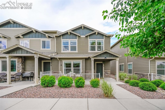 1914 Birmingham Loop, Colorado Springs, CO 80910 - view of front of house featuring board and batten siding, stone siding, covered porch, and a patio area
