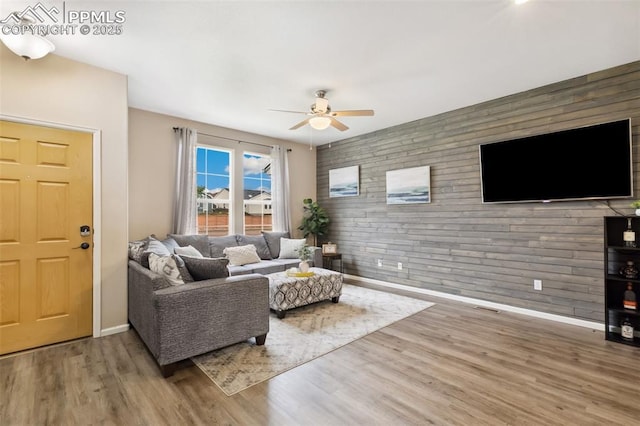 7524 Sandy Springs Pt, Fountain, CO 80817 - living room with a ceiling fan, wood finished floors, wooden walls, and an accent wall
