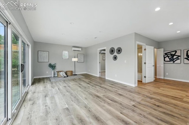 1112 Modes St, Colorado Springs, CO 80904 - unfurnished living room with a wall mounted air conditioner, light wood-type flooring, baseboards, and recessed lighting