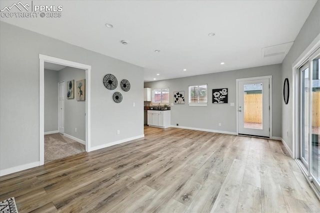 1112 Modes St, Colorado Springs, CO 80904 - unfurnished living room with light wood-type flooring, recessed lighting, baseboards, and a sink