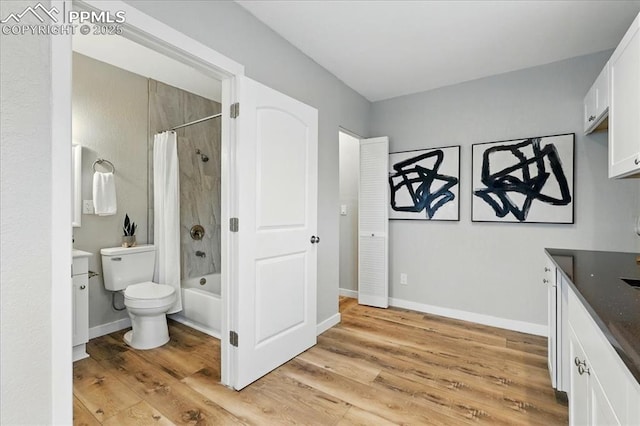 1112 Modes St, Colorado Springs, CO 80904 - bathroom with shower / bath combo with shower curtain, toilet, wood finished floors, vanity, and baseboards