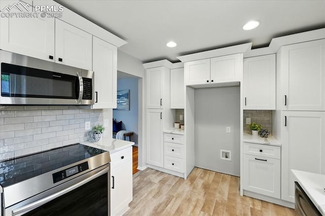 1112 Modes St, Colorado Springs, CO 80904 - kitchen with stainless steel appliances, tasteful backsplash, white cabinets, light wood-style floors, and recessed lighting