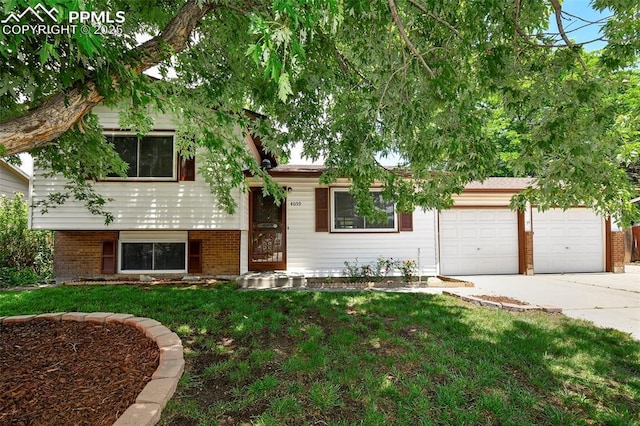 4059 Cooke Ln, Colorado Springs, CO 80911 - split level home with driveway, a front yard, an attached garage, and brick siding