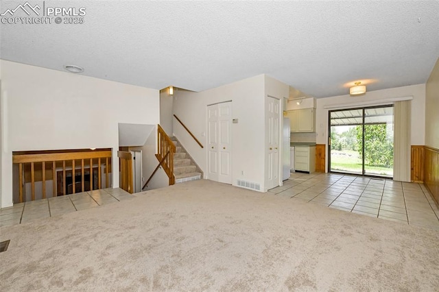 4059 Cooke Ln, Colorado Springs, CO 80911 - tiled empty room featuring a textured ceiling, carpet, and stairway