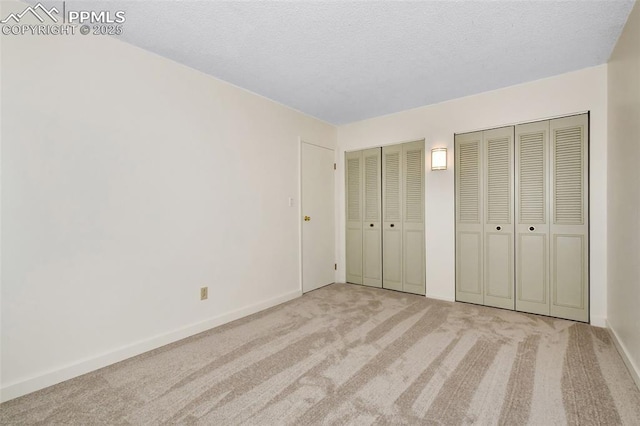 4059 Cooke Ln, Colorado Springs, CO 80911 - unfurnished bedroom with carpet floors, two closets, and a textured ceiling