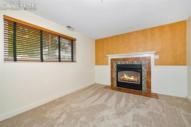 4059 Cooke Ln, Colorado Springs, CO 80911 - unfurnished living room with carpet flooring, a textured ceiling, and a tiled fireplace