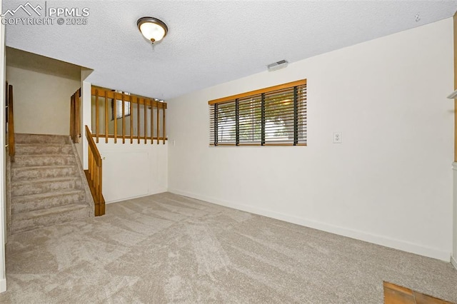 4059 Cooke Ln, Colorado Springs, CO 80911 - carpeted empty room with stairway and a textured ceiling