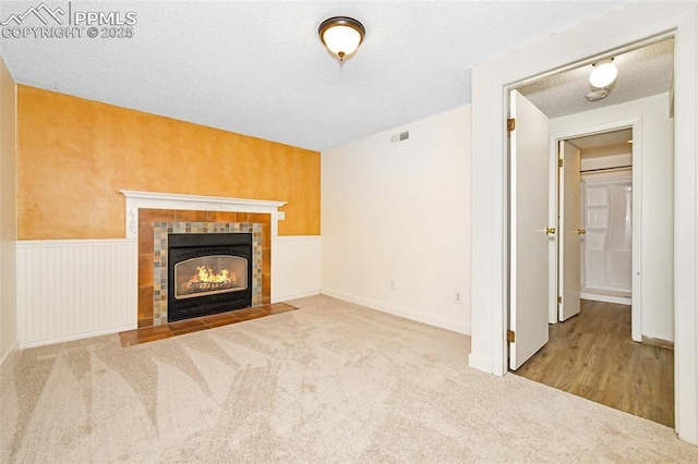 4059 Cooke Ln, Colorado Springs, CO 80911 - unfurnished living room featuring carpet floors, a fireplace, and a textured ceiling