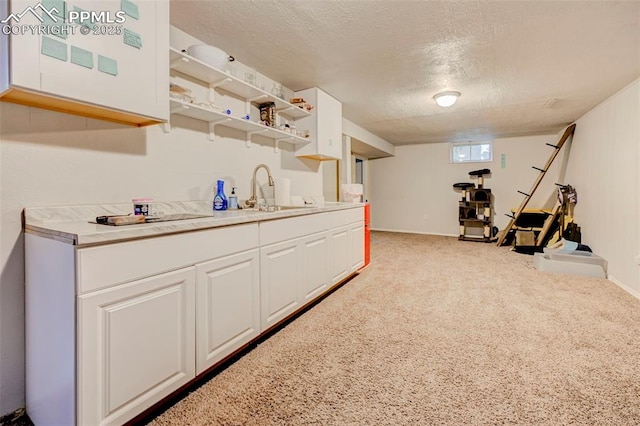 3118 E Ln Salle St, Colorado Springs, CO 80909 - kitchen with a textured ceiling, light countertops, white cabinets, open shelves, and carpet