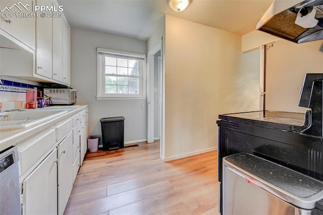 3118 E Ln Salle St, Colorado Springs, CO 80909 - kitchen with dishwashing machine, light wood-style floors, white cabinets, and ventilation hood