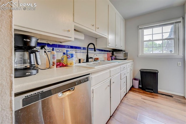 3118 E Ln Salle St, Colorado Springs, CO 80909 - kitchen featuring stainless steel dishwasher, white cabinets, light wood-style flooring, and light countertops
