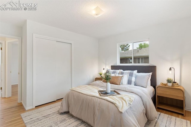 1411 Acacia Dr, Colorado Springs, CO 80907 - bedroom with a closet, light wood-type flooring, and a textured ceiling