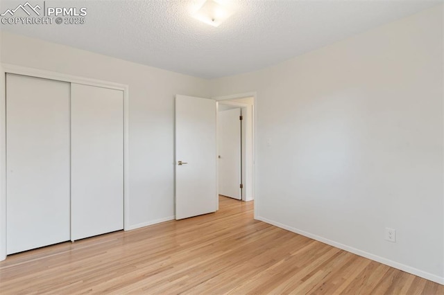 1411 Acacia Dr, Colorado Springs, CO 80907 - unfurnished bedroom with light wood-type flooring, a closet, and a textured ceiling